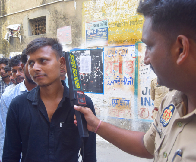 परीक्षा केंद्र में प्रवेश से पूर्व स्कैनर से अभ्यर्थी का कान चेक करते पुलिसकर्मी।जागरण